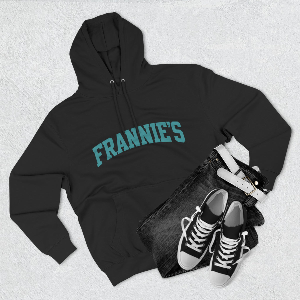 Frannie's varsity hoodie in Black: laid flat with jeans and sneakers