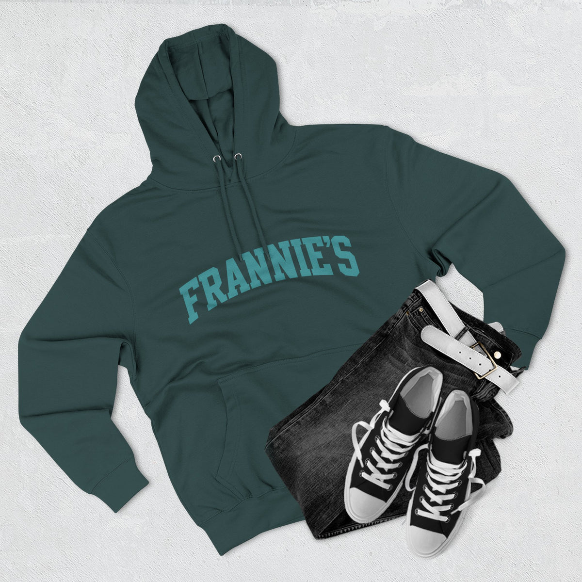 Frannie's varsity hoodie in Sports Green: laid flat with jeans and sneakers