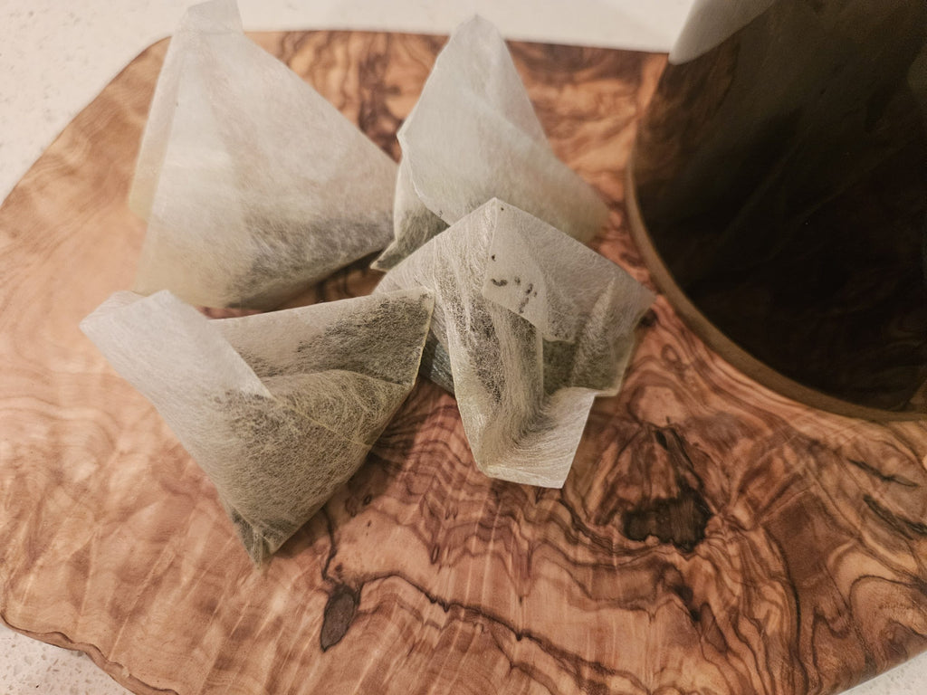 Premium Earl Grey pyramid tea bags on a wooden board