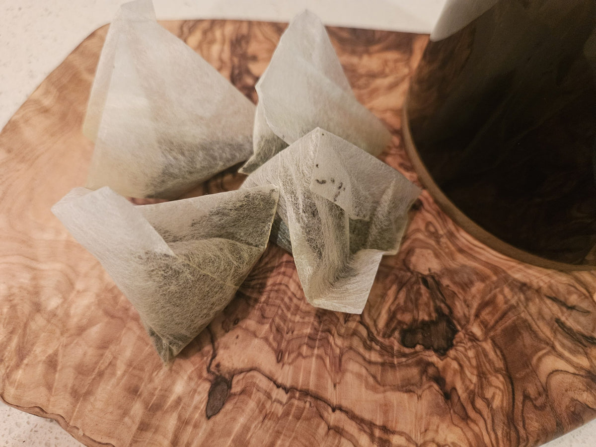 Premium Earl Grey pyramid tea bags on a wooden board