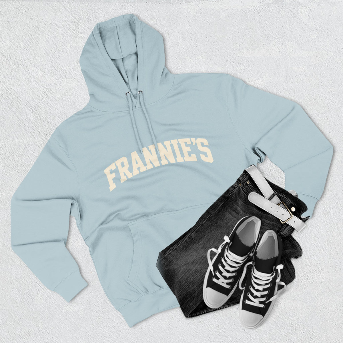 Frannie's varsity hoodie in Blue Mist: laid flat with jeans and sneakers